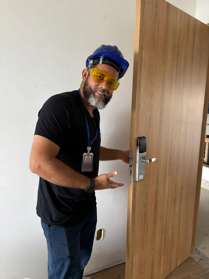 Técnico do Rei da Fechadura Digital ao lado de uma fechadura digital instalada